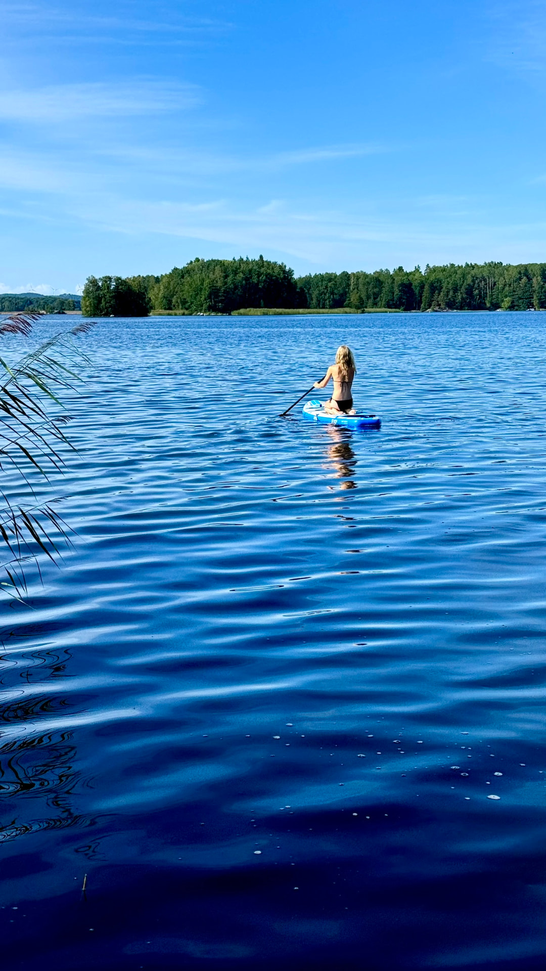 Paddling a stand-up board out across the open lake