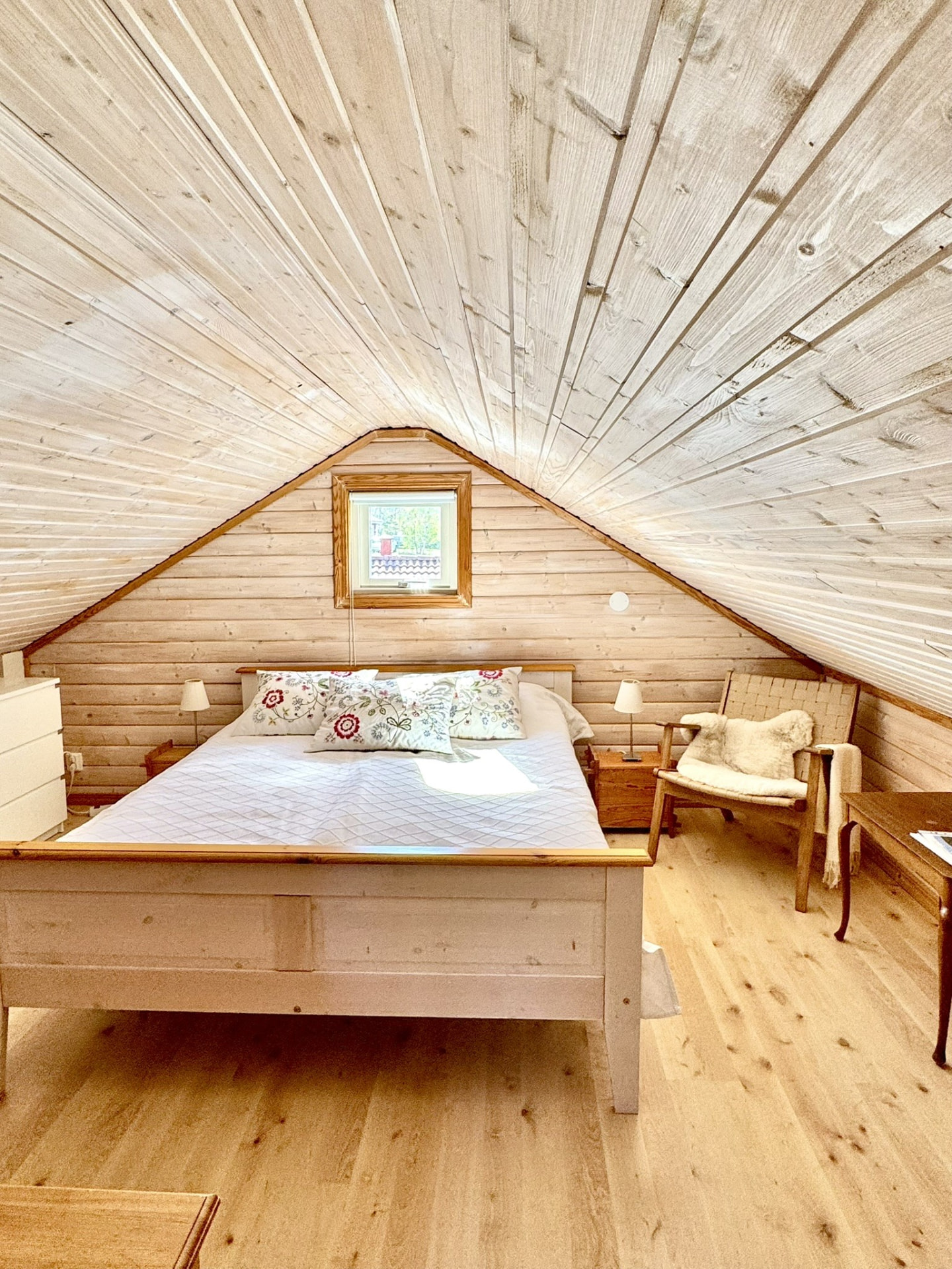 The double bed under the pale timber roof of the sleeping loft