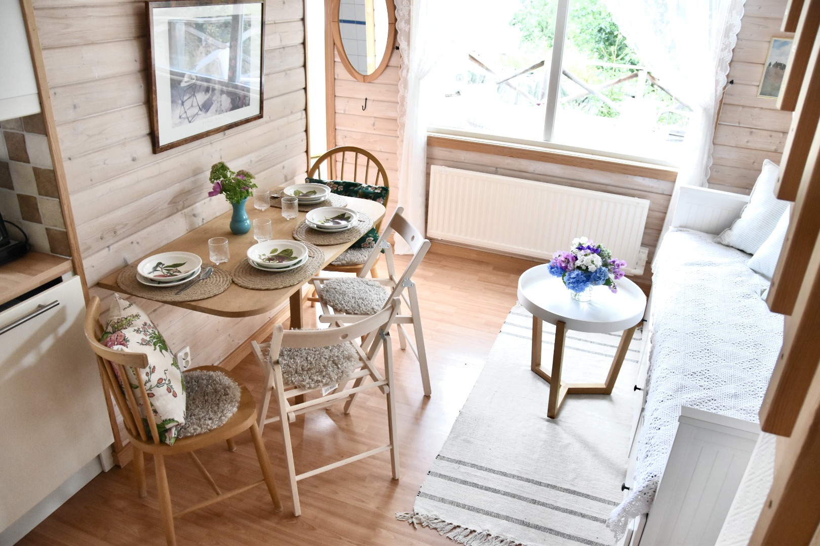 The dining table laid for four beside the window